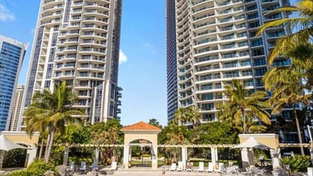 A high-rise hotel with a pool area, featuring multiple balconies and a clear blue sky. - Chevron Tower3 has 2bedrooms 2beds With Car Park (Gold Coast)