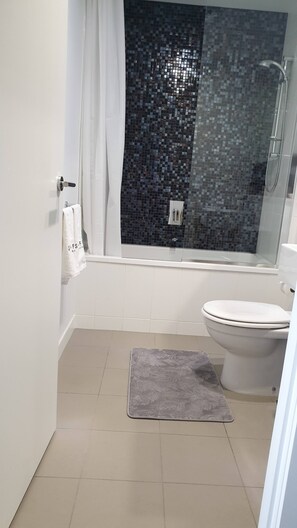 Ein Badezimmer mit Badewanne, Toilette und Dusche.