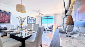 A hotel dining area with a large window, a ceiling fan, and a view of the cityscape.