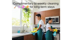 A kitchen with two individuals cleaning, a window with plants, and a microwave. - Walk to Beach, Shops, Dining, Pool View, Fast Wifi (Punta Cana)