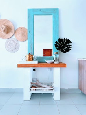 A bathroom vanity with a mirror, a wooden shelf, and a decorative plant. - Hot Tub, Pool, Walk to Fun, Beach, Dining, Shops (Punta Cana)
