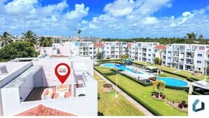 Ein Hotel mit mehreren Etagen, einer Dachterrasse und einem Poolkomplex.