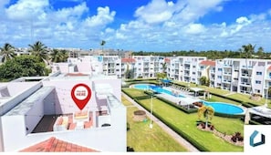 Um hotel com vários andares, área no terraço e complexo de piscinas.