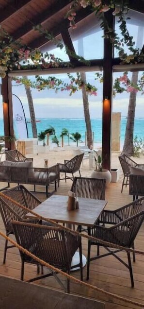 An outdoor seating area with wicker furniture and a view of the ocean. - Private Plunge Pool Rooftop Penthouse Near Beach (Punta Cana)