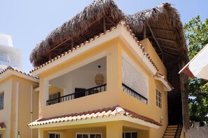 Un bâtiment à deux étages, doté d’un toit de chaume et d’un balcon.