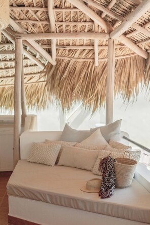 A bed with a thatched roof structure above it.