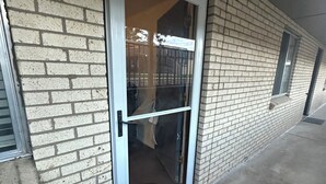 A building with a glass door, brick walls, and a concrete floor. - Location location location ! (Lakewood)