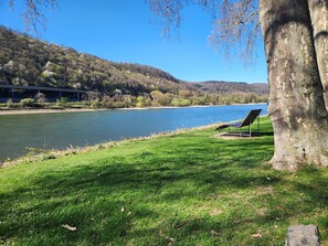 A grassy area with a bench and a tree, overlooking a river and a bridge. - Apartment 'Punkt15' with Private Terrace, Garden, and Wi-Fi (Leutesdorf)