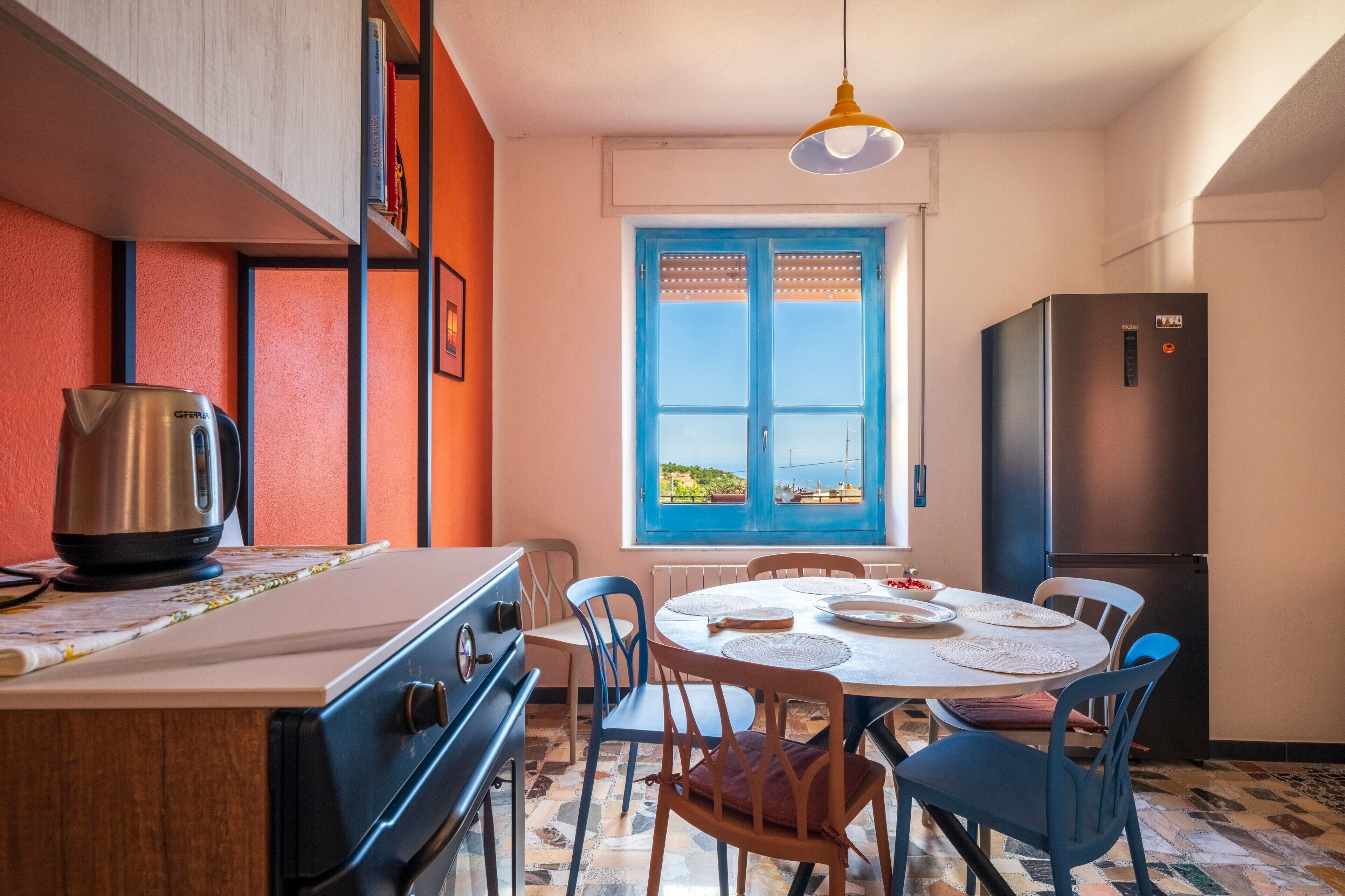 Une cuisine équipée d’une cuisinière, d’une bouilloire et d’une table à manger avec des chaises.