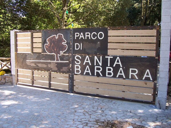 A wooden gate with a sign that reads 'Parco di Santa Barbara.' - Holiday Home 'Sa Omu 'Eccia' with Sea View and Private Terrace (Villagrande Strisaili)