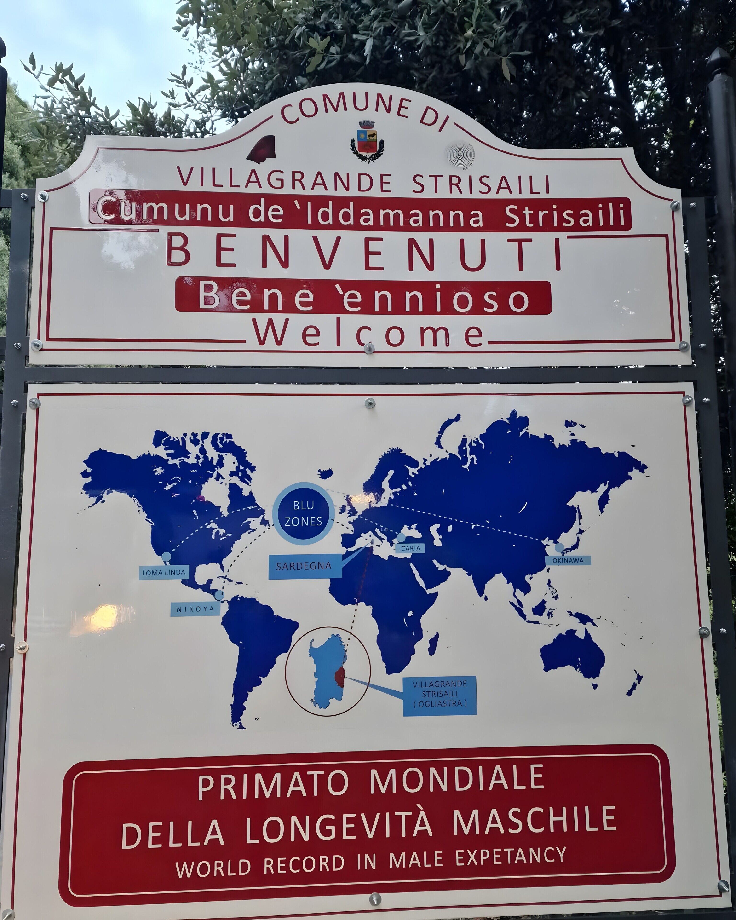 A welcome sign for Villagrande Strisaili, featuring a world map highlighting its location.