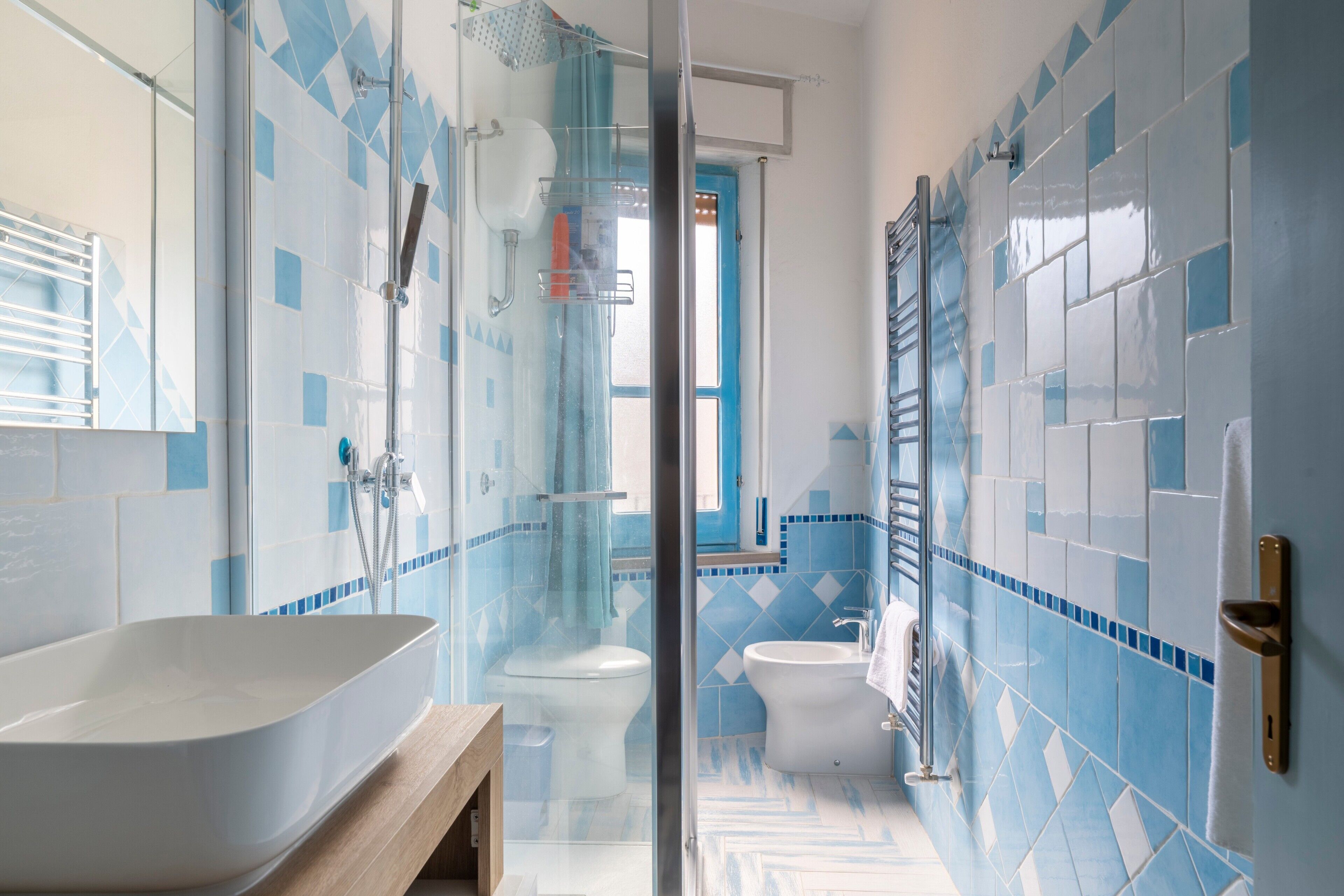 Une salle de bain avec une baignoire sur pieds, une douche à parois de verre et des toilettes.