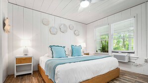 A bedroom with a wooden bed, white walls, and a window with blinds. - Cozy Cottage Near Siesta Key Village! (Siesta Key)