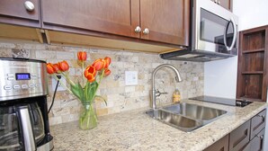 A kitchen with a coffee maker, a sink, and a vase with tulips. - Walk to Village & 5C's & Trader Joe's/Private Pool (Claremont)
