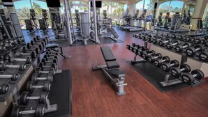 A gym with various exercise equipment, including treadmills, weight machines, and free weights. - Mi Casa WestGate Lakes & spa Resort (Orlando)