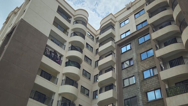 A multi-story residential building with balconies, large windows, and a mix of brick and plaster exteriors. - Studio Apartment Near JKIA and SGR (Syokimau)