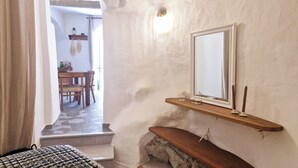 A room with a wooden bench, a mirror on the wall, and a small shelf with candles. - Sublime atypical apartment with terrace in the heart of ERBALUNGA (Brando)