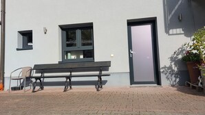Un edificio con una panchina, una porta e una finestra.