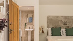 A bedroom with a bed, a bedside table, a nightstand, and a large mirror. - A cosy, base for two in Windermere, perfect for laid-back Lake District getaways. (Windermere)