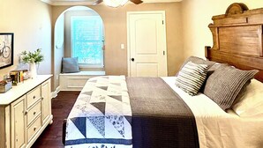 A bedroom with a bed, a nightstand, a dresser, a window with blinds, and a door. - Charming Country Getaway in Reilly Springs (Sulphur Springs)