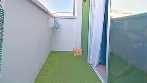 A balcony with artificial grass, a sliding glass door, and a view of the sky. - Self-contained apartment, The Greey's House F (El Calero)