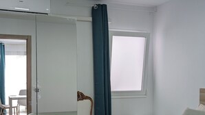 A hotel room with two beds, a window, a mirror, and a ceiling light. - Self-contained apartment, The Greey's House F (El Calero)