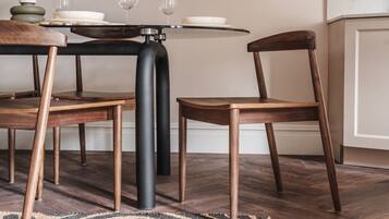A dining area with a round table, two chairs, and a black metal base.