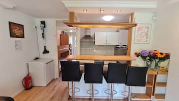 Een koelkast, een magnetron, een oven, kookgerei, borden en bestek