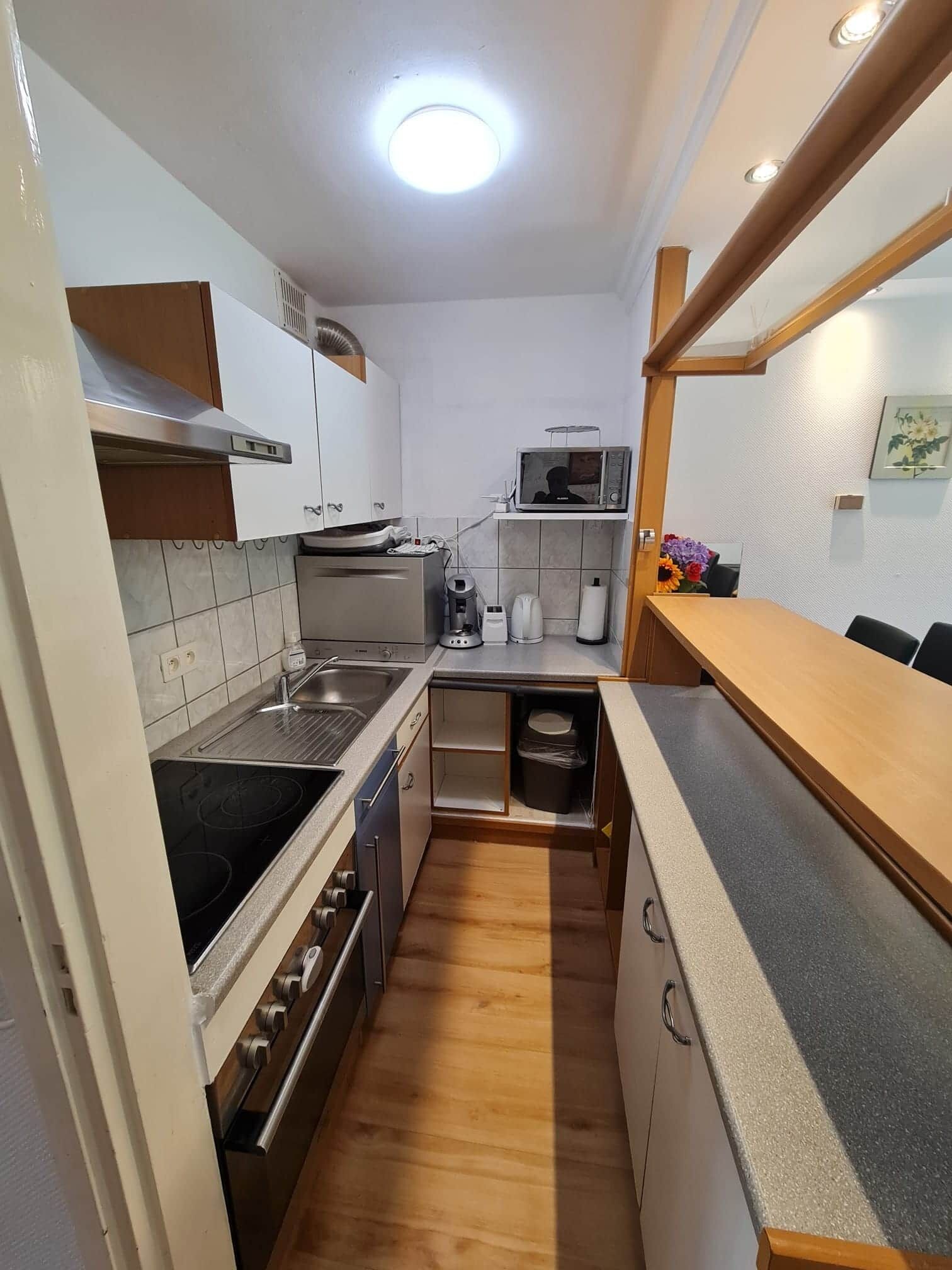 A compact kitchen with a stove, microwave, and sink.