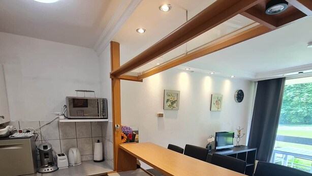 A compact kitchen with a microwave, coffee maker, and a small sink. There is a wooden counter and cabinets, and a window providing natural light. - Pause Nature 30N _ living in nature in peace and quiet (Kelmis)