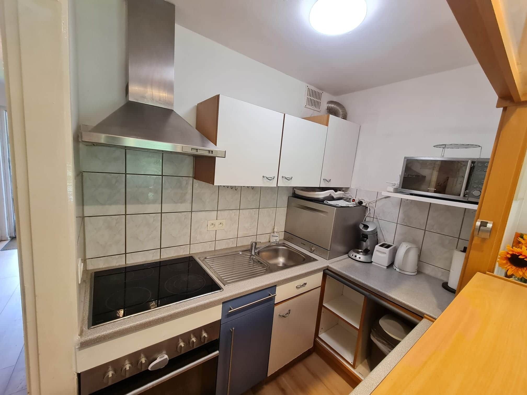 A compact kitchen with a gas stove, microwave, and built-in oven.