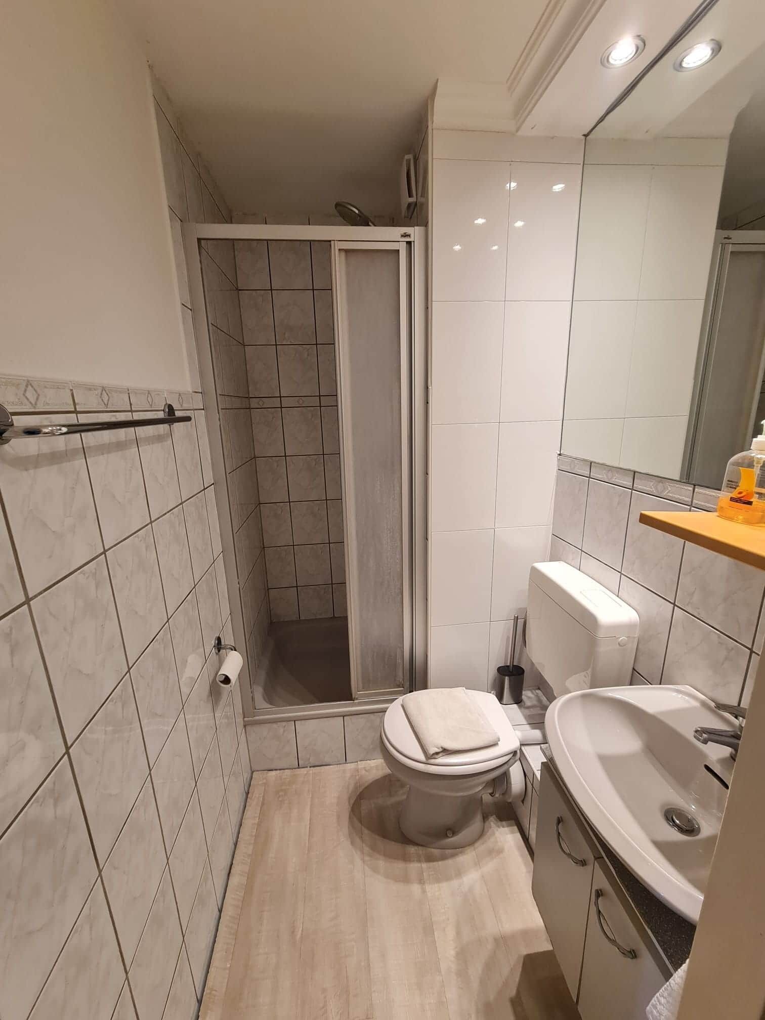 A compact bathroom with a shower, toilet, and sink.