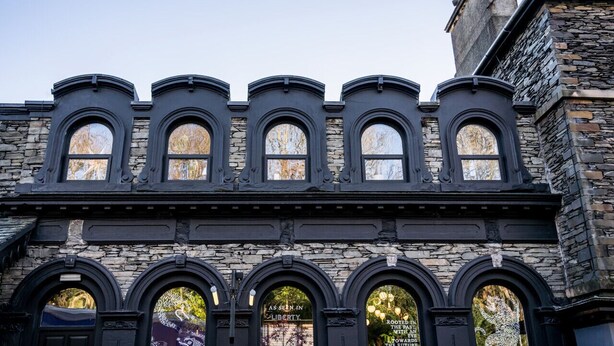 Um edifício com fachada de pedra e várias janelas em arco.