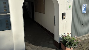 An entrance with a metal sign reading "Haus Schöneke," a parking sign, and a flower pot. - Schönblick House B6 · Large Panoramic Terrace (Schöfweg)