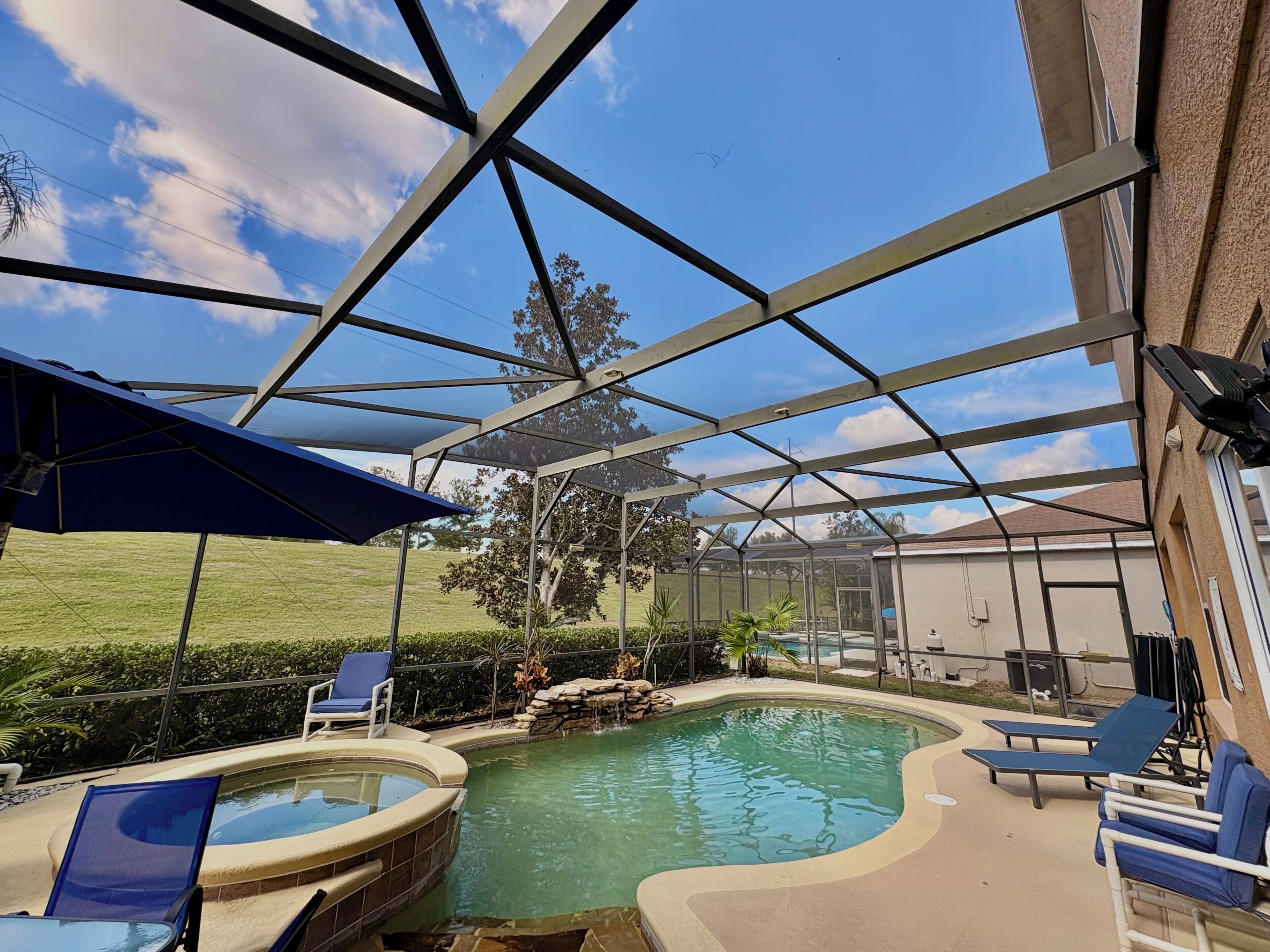Ein überdachter Außenpool mit Liegestühlen und einer Pergola.