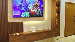 A television mounted on a wooden wall with a wooden cabinet below. - Charming 2-bedroom flat 10 minutes to the beach (Agadir)
