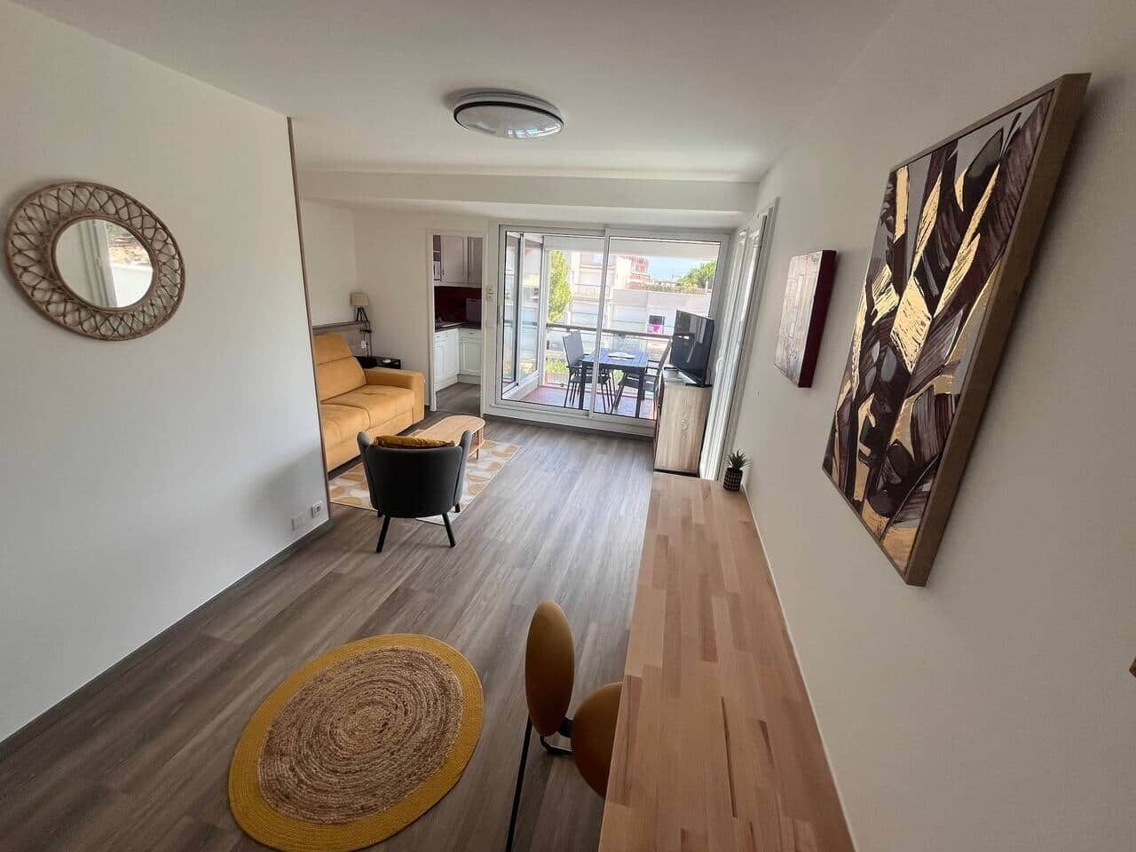 A modern living room with a sofa, chairs, a coffee table, and a large window.