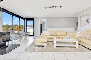 A modern living room with a sofa, coffee table, and a fireplace.