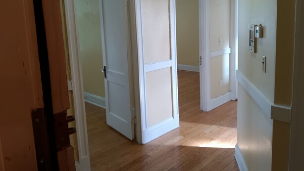 A hallway with wooden floors and white doors leading to rooms. - Charming 2-bedroom apartment in Cleveland Circle Boston, Near BC, BU (Boston)