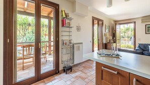 A kitchen with a large island, wooden cabinets, and a view of the outdoor patio.