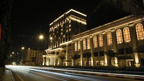A multi-story hotel with illuminated windows and a prominent entrance.