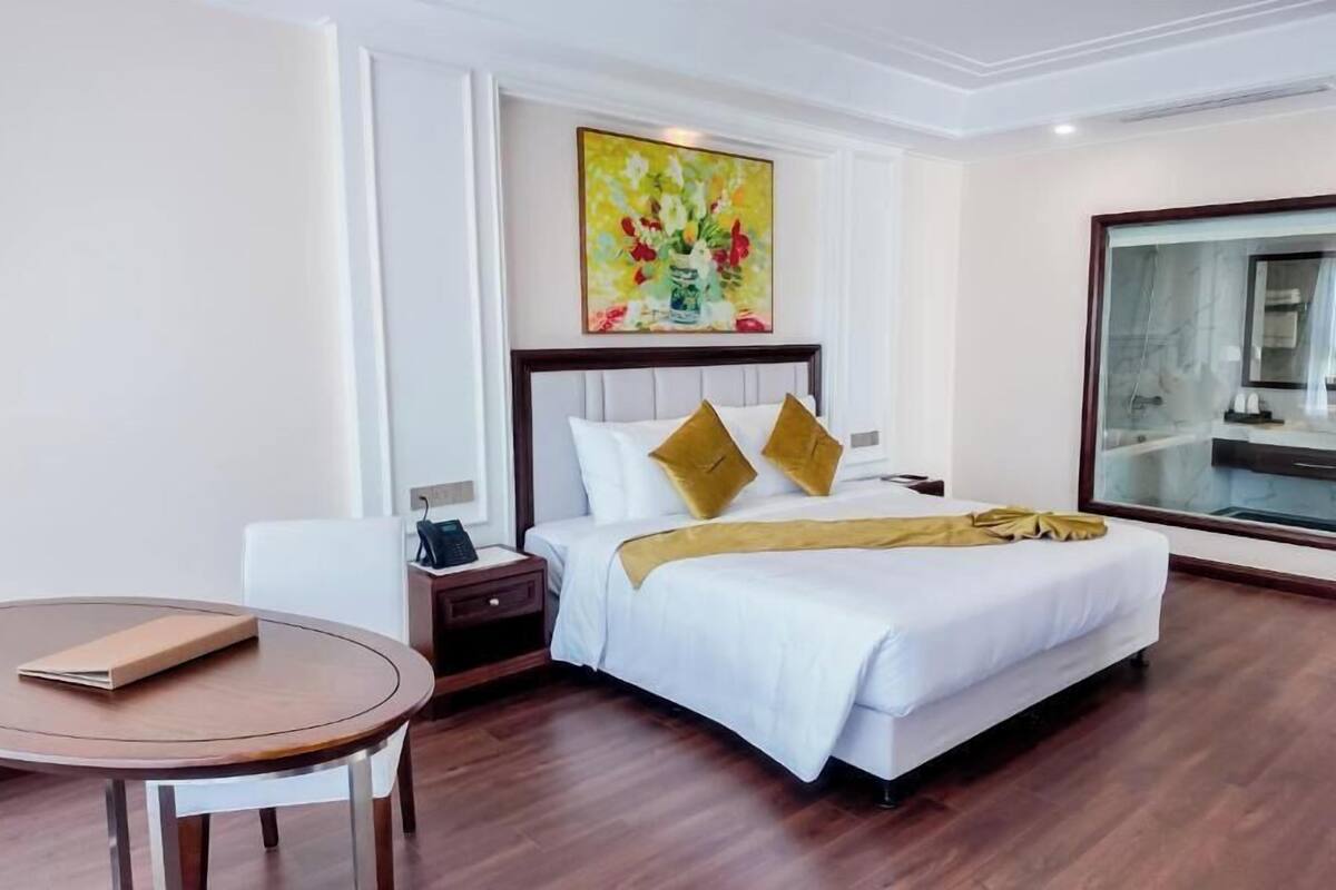 Una habitación de hotel con cama, mesita de noche y una mesa redonda.