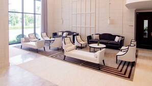 A spacious lobby with a large window, modern furniture, and a chandelier.
