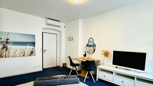 A modern room with a bed, a desk, a TV, and a painting on the wall. - Comfy Room Shared Apt, 13-min to Belvedere Palace (Vienna)