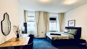 A room with a bed, a desk, a chair, a mirror, and a window. - Comfy Room Shared Apt, 13-min to Belvedere Palace (Vienna)