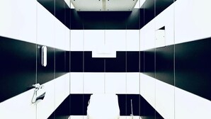 A modern bathroom with a white toilet, a sink, and a mirror. - Comfy Room Shared Apt, 13-min to Belvedere Palace (Vienna)