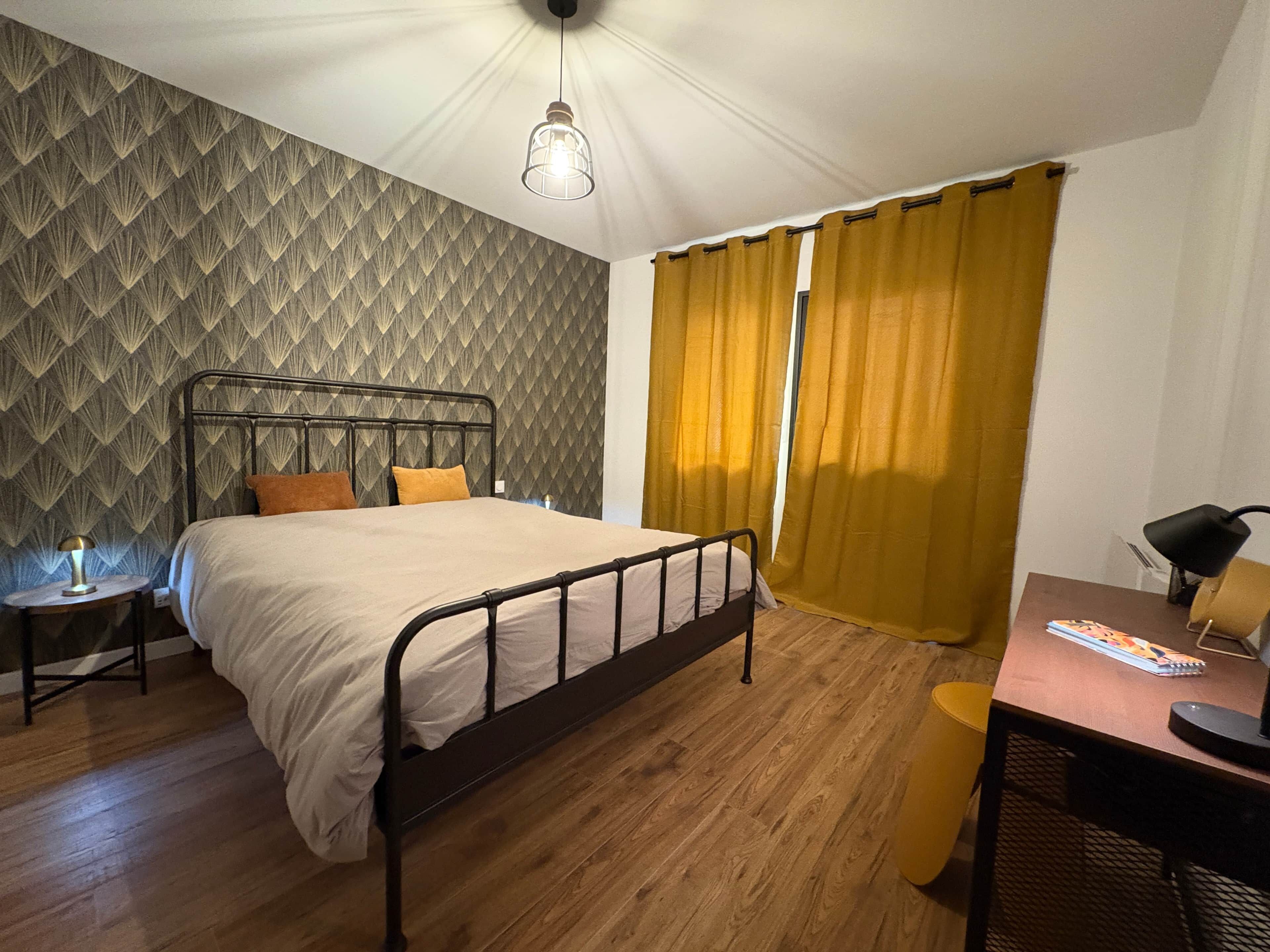 Ein Schlafzimmer mit einem Bett, einem Nachttisch, einem Schreibtisch und einem Stuhl.