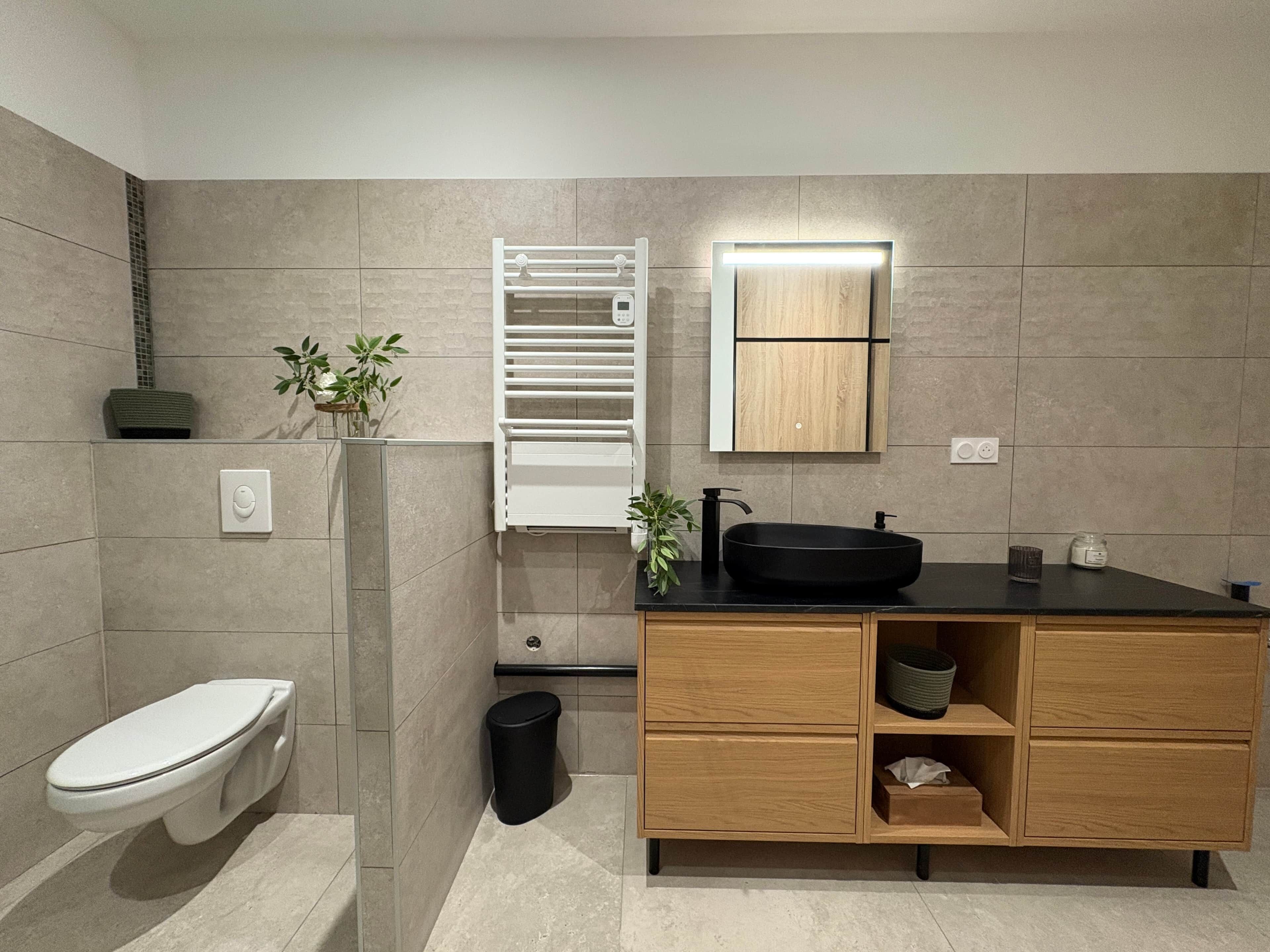 Ein modernes Badezimmer mit Toilette, Waschbecken und integriertem Schrank.