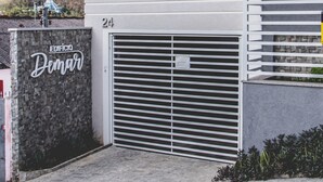 A modern building with a stone facade, a garage door, and a small window. - Tima Kitnet Prox Unifei com Wi-fi e Smart TV (Itajuba)
