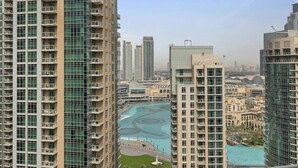 A high-rise building with multiple balconies, a central courtyard with a pool, and surrounding high-rise buildings. - SIMPLY COMFORT Luxury Burj Khalifa & Fountain View Apartments Steps to Dubai Mall (Dubai)